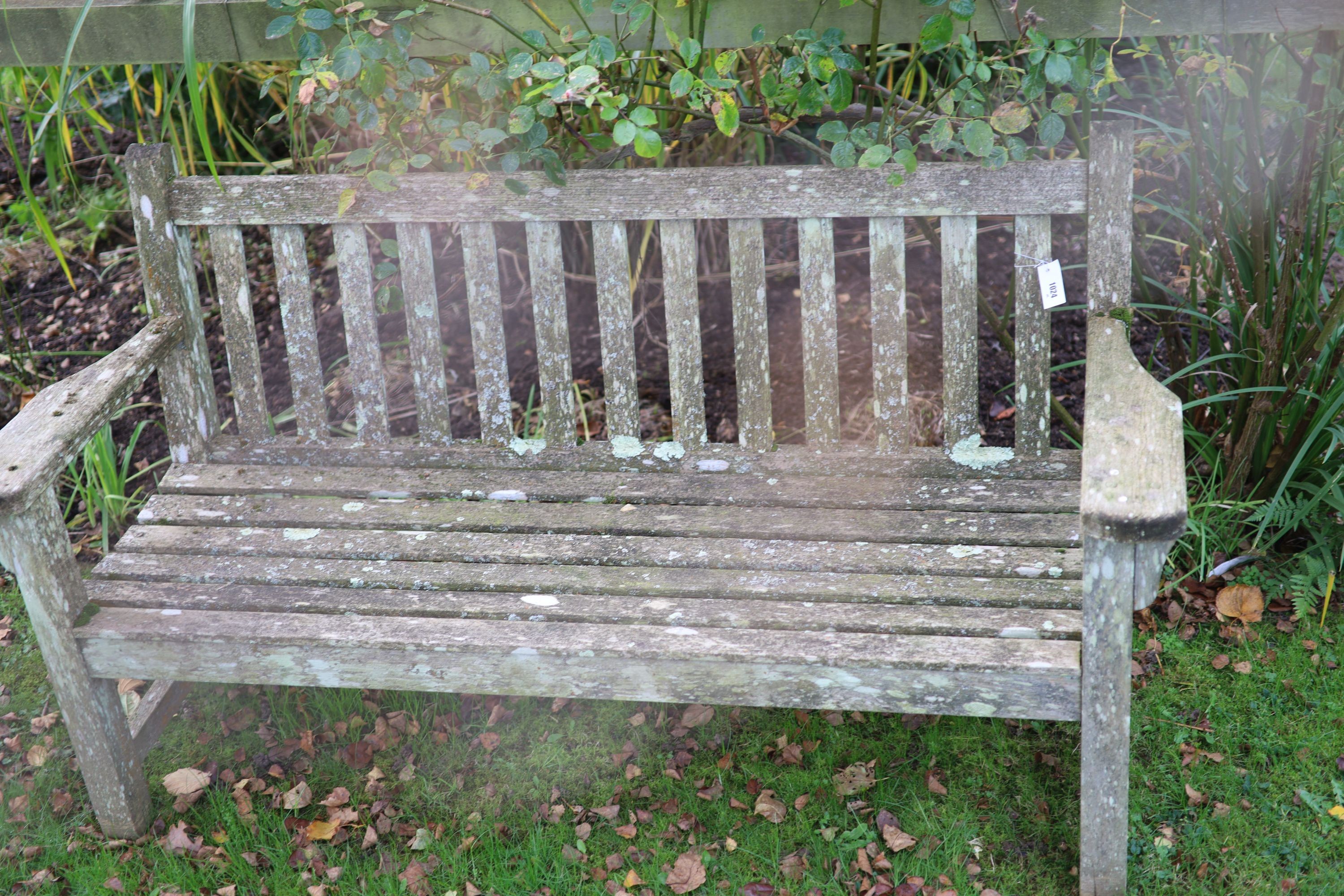 A pair of weathered teak garden benches, width 158cm